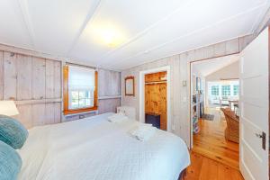 een slaapkamer met een wit bed en houten lambrisering bij Old Wharf Escape in Dennis Port