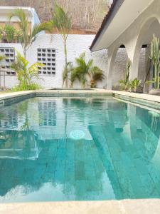 a swimming pool in front of a house at Palmhouse Boutique Hotel in Kuta Lombok +33 photos