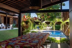 a patio with a table and a swimming pool at Prive de Veraneio in Porto De Galinhas