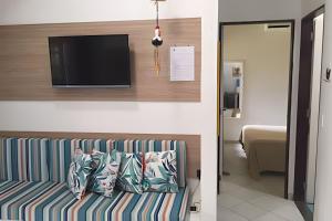 a living room with a couch and a tv at Prive de Veraneio in Porto De Galinhas