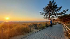 a person riding a bike on a path near the beach at Przy Brzegu - Hel studio in Hel