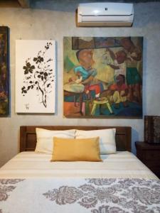 ein Schlafzimmer mit einem Bett und einem Gemälde an der Wand in der Unterkunft Kampung Baron Cottage in Yogyakarta
