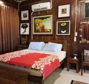 ein Schlafzimmer mit einem Bett mit einer roten Decke in der Unterkunft Kampung Baron Cottage in Yogyakarta