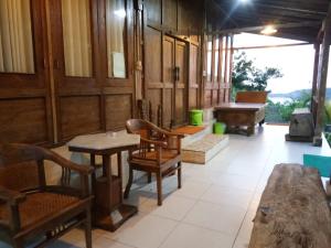 ein Zimmer mit Stühlen und Tischen in einem Gebäude in der Unterkunft Kampung Baron Cottage in Yogyakarta