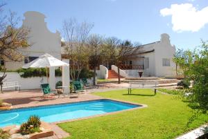 a backyard with a swimming pool and a house at Naries Namakwa Retreat in Goop