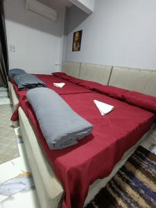 un letto con lenzuola rosse e carta bianca di Eljoker pyramids hostel a Il Cairo