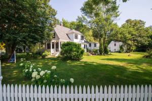 a white picket fence in front of a house at Shopping Restaurants 6 mins to Beach AC in Yarmouth