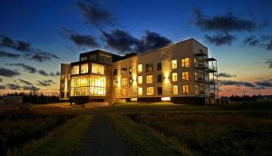 a large building with its lights on at dusk at Blackbush Beach Resort in Covehead