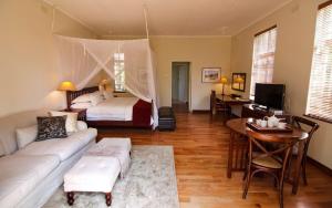 une chambre avec un lit et un salon avec un canapé dans l'établissement Chic studio nestled in lovely garden and pool-2254, à Harare
