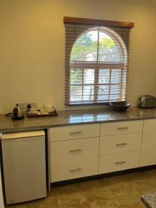 eine Küche mit einer Arbeitsplatte und einem Fenster in der Unterkunft Modern studio set in an expansive garden - 2253 in Harare + 3 Fotos