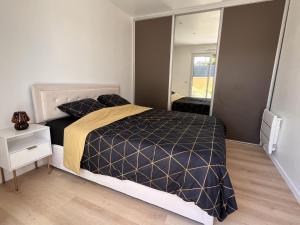 a bedroom with a bed and a large mirror at Maison au Pays de Fontainebleau in Vulaines-sur-Seine +12 photos