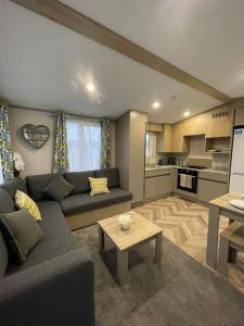 a living room with a couch and a table at BRAND NEW 6 berth holiday home in Selsey