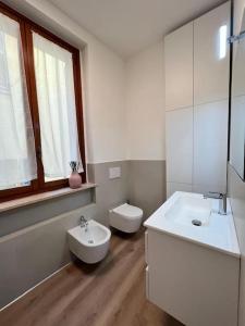 a white bathroom with a sink and a toilet at Comfort moderno centro città in Ancona +5 photos
