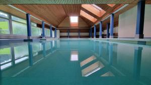 an empty swimming pool with a ceiling and windows at Residenza Tga Clo Apartment C119 in Savognin