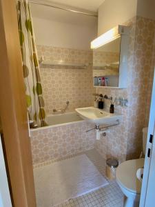 a bathroom with a sink and a tub at Residenza Tga Clo Apartment C17 in Savognin