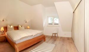 a white bedroom with a bed and a window at Haus 161, Lärchenweg 10 in Ostseebad Karlshagen