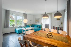 a living room with a table and a blue couch at Haus 172, Lärchenweg 1 in Ostseebad Karlshagen