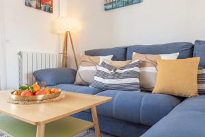 een blauwe bank met een fruitschaal op een tafel bij El Faro in L'Escala