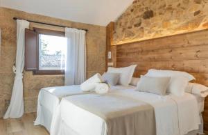 a bedroom with two beds with white sheets and a window at O Fogar da Pequena Galia in Caldas de Reis +20 photos