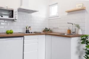 a kitchen with white cabinets and a sink at Estudio Bianca in L'Escala