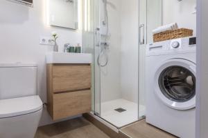 a bathroom with a washing machine and a toilet at Estudio Bianca in L'Escala