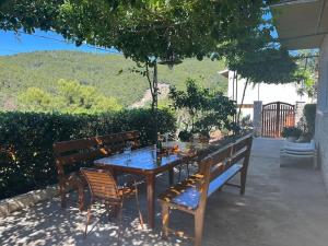 a wooden table and chairs with a blue table and benches at Holiday house Ivko - Korcula in Vela Luka +39 photos