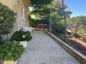 a walkway leading to a patio with a table and chairs at Holiday house Ivko - Korcula in Vela Luka