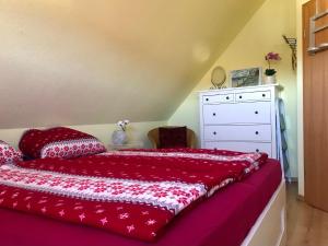 1 dormitorio con 1 cama con sábanas rojas y vestidor en FeWo 72 4, Sanddornweg 2 g, en Ostseebad Karlshagen