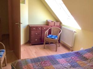 1 dormitorio con vestidor, silla y cama en FeWo 72 4, Sanddornweg 2 g, en Ostseebad Karlshagen 3 fotos más