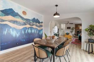 a dining room with a large painting on the wall at Watkins Glen Hot Tube Retreat- Finger Lakes Region in Burdett