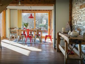 a dining room with a table and red chairs at La Ferme des Artistes - OVO Network in Mieussy