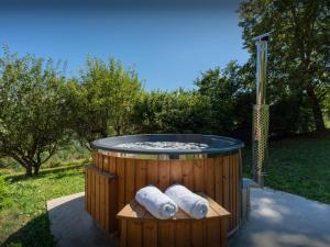 a hot tub with two towels in a yard at La Ferme des Artistes - OVO Network in Mieussy