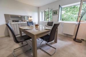 a dining room with a wooden table and chairs at Gîte les agréou in Arjuzanx