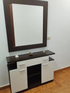 a white dresser with a mirror on a wall at A casiña de Tuli in Vigo +3 photos