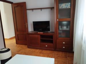 a living room with a tv and a entertainment center at A casiña de Tuli in Vigo