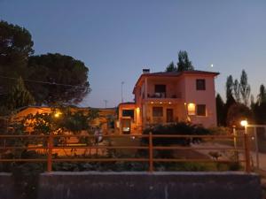 a house with a fence in front of it at night at Villa Angela in Sikia