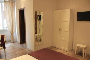 ローマにあるB&B Gallia's Roomsのベッドルーム(ベッド1台、クローゼット、テレビ付)