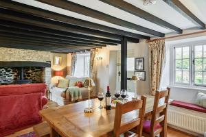 a living room with a wooden table and a couch at Strand Cottage in Burton Bradstock