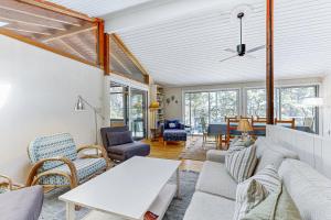a living room with a couch and chairs and a table at Drummer Cove Retreat in Wellfleet