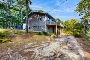 a house on the side of a dirt road at Drummer Cove Retreat in Wellfleet
