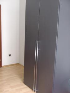 ein grauer Kühlschrank in einem Zimmer mit Holzboden in der Unterkunft Ferienwohnung Bankwitz in Köln