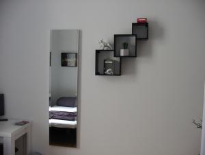 einen Spiegel an der Wand mit einem Bett in einem Zimmer in der Unterkunft Ferienwohnung Bankwitz in Köln