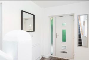 a white room with a door and a mirror at Good Location Free Parking Big Garden Modern House in Swindon