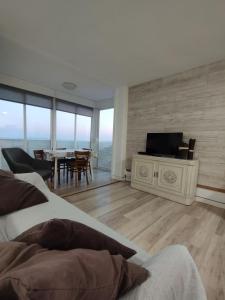 a living room with a television and a dining room at Grandpa Beach House in Alicante