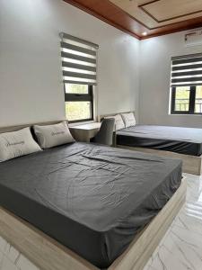 a bedroom with two beds and a table and windows at Memory House in Phúc Yên