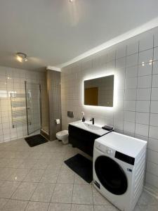 a bathroom with a sink and a toilet and a mirror at 4-room spacious condo w patio in Reykjavík +14 photos