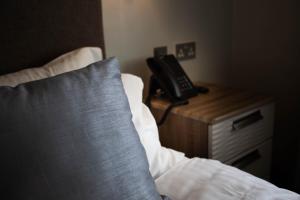 a bed with a phone on a night stand next to a bed with a pillow at Kinloch Hotel, Isle of Arran in Blackwaterfoot