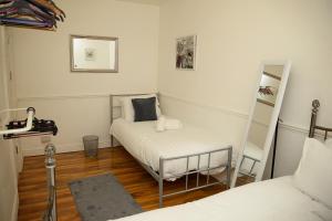 a small room with a bed and a mirror at Cosy Orrell Park Retreat Near Anfield and Aintree in Liverpool