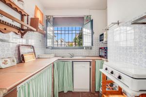 a kitchen with a sink and a stove at -Iponubahomes- Céntrica casa con jardín y chimenea in Baena