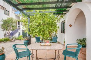 a patio with a table and chairs and a tree at -Iponubahomes- Céntrica casa con jardín y chimenea in Baena